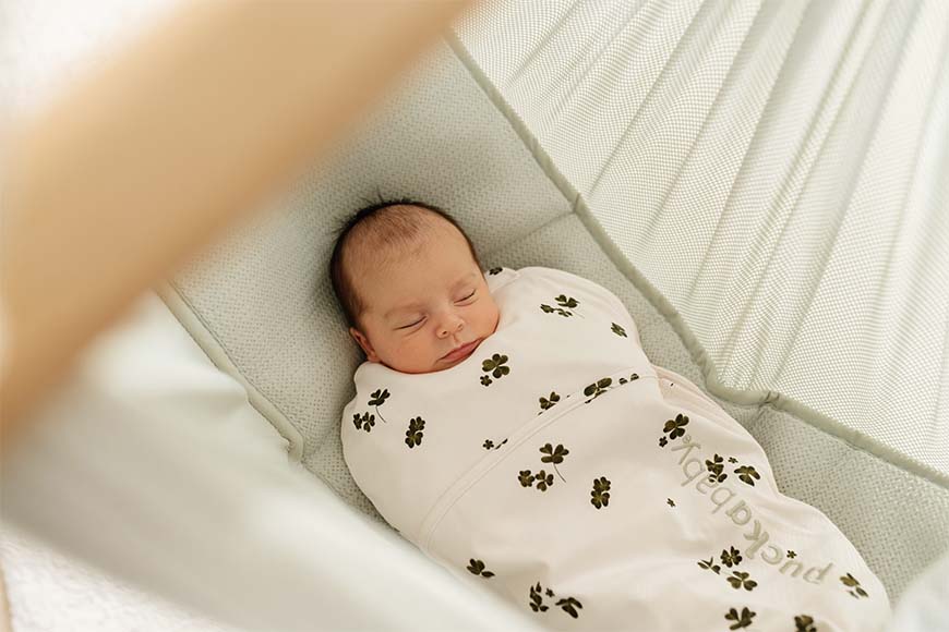 Baby in Puckababy swaddle bag sleeps in a hammock