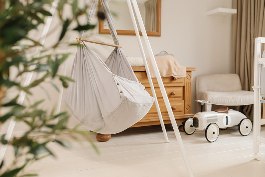 Federwiege montiert auf einem Tipi-Ständer steht im Schlafzimmer des Babys