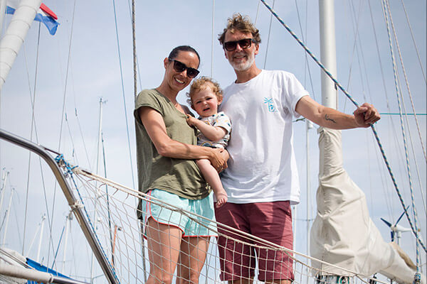 Family Lübeck stands on the sailboat and looks into the camera