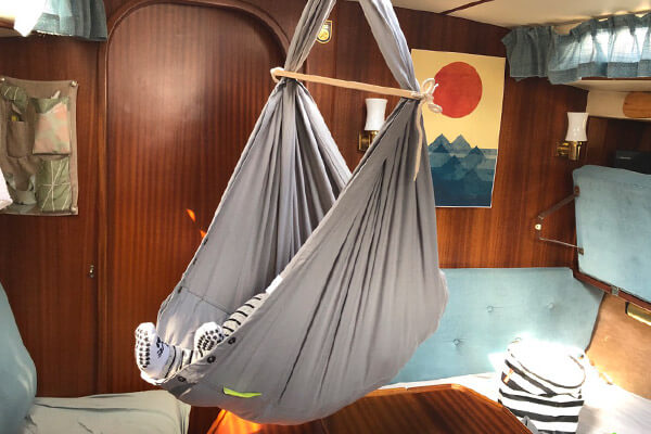 NONOMO swinging hammock fixed in the cabin. Feet of the baby visible