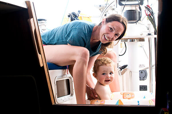 Frau Lübeck with baby are on the sailboat and look through the open cabin door